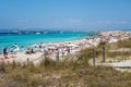 Torquoise color of the water with white sand in sunny day the Ses Illetes beach full of people