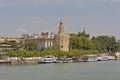 Torre del Oro, historical watchtower along Guadalquivir river with tourist boats in front in Sevilla.