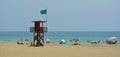 Torremolinos Beach with holiday makers and watch tower with green flag.