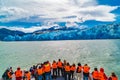 Tourists with orange color life jackets on a sightseeing boat excursion to the Grey Glacier