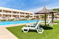 Empty area with deckchairs and swimming pool during sunny summer day Royalty Free Stock Photo