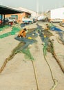 Fisherman mending fishing nets in the port in coastline of Torrox