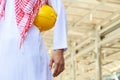 Torso of arab engineer or worker hold in hand yellow helmet