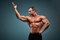 Torso of attractive male body builder on gray background. Royalty Free Stock Photo