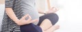 Torso close-up of pregnant woman. Pregnant fitness woman sitting in yoga crossed-leg pose . Pregnancy Yoga