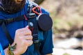 Torso of equipped hiker with speaker, compass and water pipe