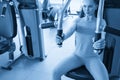 Torso portrait of Cheerful young adult caucasian woman working out on exercise machine inside gym Royalty Free Stock Photo