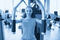 Torso portrait of Cheerful young adult caucasian woman working out on exercise machine inside gym Royalty Free Stock Photo