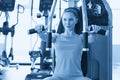 Torso portrait of Cheerful young adult caucasian woman working out on exercise machine inside gym Royalty Free Stock Photo