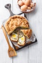 Torta Pasqualina traditional Italian savory pie with spinach, chard, ricotta and whole eggs closeup on the wooden board. Vertical Royalty Free Stock Photo
