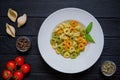 Tortellini cooked pasta with differed kinds of pepper, allspice, red tomato and green pepper. Italian cuisine on wooden rustic ta Royalty Free Stock Photo