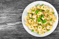 Tortellini with green peas, fried Pine nuts, top view