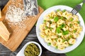 Tortellini with green peas, fried Pine nuts, top view