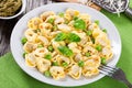 Tortellini with green peas, fried Pine nuts, top view