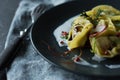 Tortellini pasta dish on black plate, close-up view Royalty Free Stock Photo