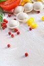 Tortellini and vegetables on white wooden background