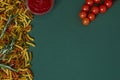 Tortiglioni tricolore raw pasta, tomatoes, tomatoes sauce on dark green background Royalty Free Stock Photo