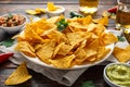 Tortilla nachos chips with cheese sauce, guacamole and tomatoes salsa dip. glass of beer. Royalty Free Stock Photo