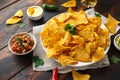 Tortilla nachos chips with cheese sauce, guacamole and tomatoes salsa dip. glass of beer. Royalty Free Stock Photo