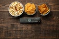 Tortilla popcorn, chips and TV remote on a brown wooden background. concept of watching movies at home. view from above Royalty Free Stock Photo