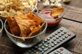 Tortilla and popcorn, TV remote on a brown wooden background. concept of watching movies at home. close-up Royalty Free Stock Photo