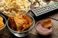 Tortilla and popcorn, TV remote on a brown wooden background. concept of watching movies at home. close-up Royalty Free Stock Photo