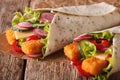 Tortilla roll with fish fingers, cheese and vegetables close-up. Horizontal Royalty Free Stock Photo