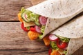 Tortilla roll with fish fingers, cheese and vegetables close-up. horizontal top view Royalty Free Stock Photo
