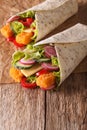 Tortilla roll with fish fingers, cheese and vegetables close-up. vertical Royalty Free Stock Photo