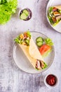 Tortilla wrap with cucumber, chicken and tomato on a plate. Mexican cuisine. Top and vertical view Royalty Free Stock Photo