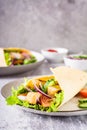 Tortilla wrap with cucumber, chicken and tomato on a plate. Mexican cuisine. Vertical view Royalty Free Stock Photo