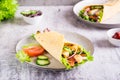 Tortilla wrap with cucumber, chicken and tomato on a plate on the table. Mexican cuisine Royalty Free Stock Photo