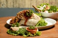 Tortilla wraps with meat and vegetables on a wooden table. Royalty Free Stock Photo