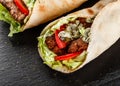 Tortilla wraps with roasted chickpeas falafel patties, fresh vegetables and salad on black stone background. Healthy snack Royalty Free Stock Photo