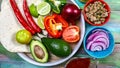 Tortillas flat and various vegetables for tacos or burrito making on rustic background, top view, border Mexican cooking recipe