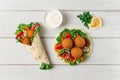 Tortillas, wrapped falafel balls, with fresh vegetables, vegetarian healthy food, on a wooden white background, no