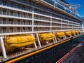 A row of yellow, enclosed lifeboats on a cruise ship in the Caribbean