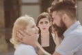 Tortures of jealousy. Bearded man cheating his woman with another girlfriend. Jealous girl look at couple in love on Royalty Free Stock Photo