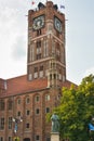 Torun, Poland - August 19, 2022: Tower of Old Town Hall and Statue of Nicolaus Copernicus in center of polish city Torun. Historic