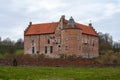 Torup, Sweden - April 1, 2020: The medieval brick castle is surrounded by a brick wall in a castle garden Royalty Free Stock Photo