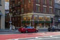 The Tory Burch store in a red brick building with cars driving on the street at Union Square in San Francisco California