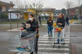 A line of people with face masks standing in line with shopping carts to stock up groceries. Italians prepare for lockdown