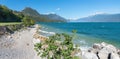 Toscolano beach, lake shore Gardasee, with rocks and gravel, mountain view