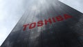 Toshiba Corporation logo on a skyscraper facade reflecting clouds. Editorial 3D rendering