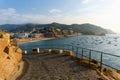 Tossa de Mar, Catalonia, Spain, August 2018. View from the side of the road to the old fortress on the beach and the harbor. Royalty Free Stock Photo