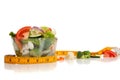 Tossed salad and tape measure on white Royalty Free Stock Photo