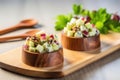 tossing waldorf salad with a pair of wooden salad servers