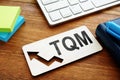 Total Quality Management TQM concept. Report on a desk Royalty Free Stock Photo