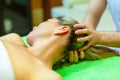 Total relaxation. Beautiful young woman lying on her back while professional massage therapist massaging her head