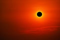 Total solar eclipse on clear red orange sky sunset in evening Royalty Free Stock Photo